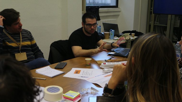 Alessandro Cataldo al tavolo di lavoro con un gruppo di partecipanti, davanti alle schede di Agritech 4 Open Innovation