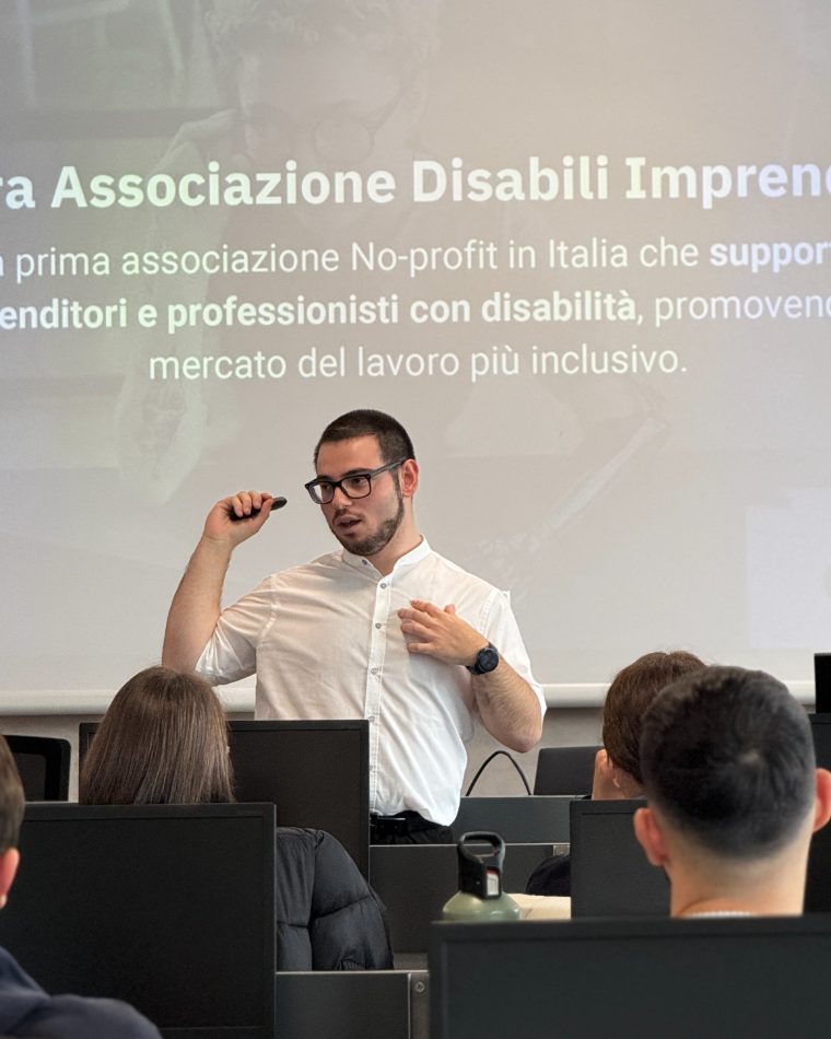 Alessandro Cataldo parla davanti agli studenti, con alle spalle la slide della Libera Associazione Disabili Imprenditori proiettata